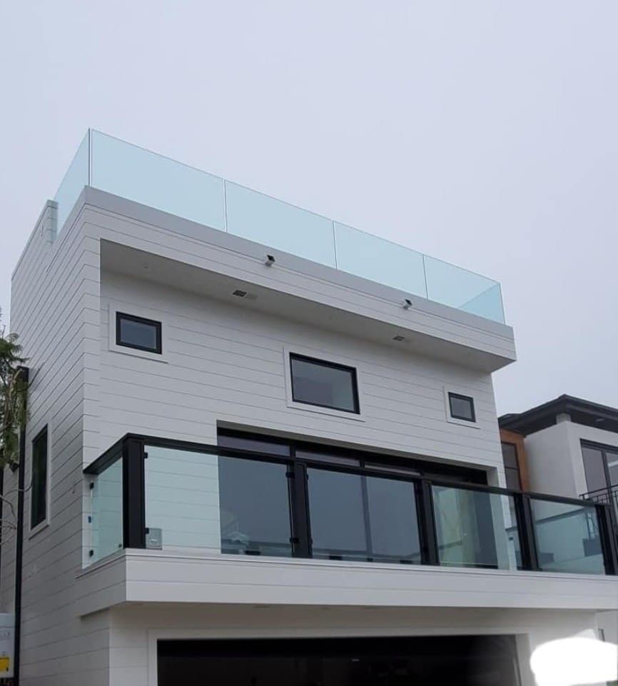 Beach house exterior with glass railings on the balcony and the roof deck